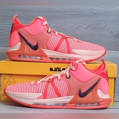 a pair of pink nike shoes sitting on top of a yellow box