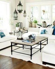 a living room filled with white furniture and lots of windows