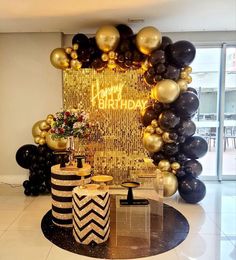 a birthday party with black and gold balloons