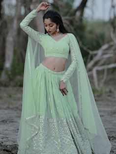 This exquisite ensemble exudes elegance and charm with its pastel green color and intricate detailing. Crafted from high-quality georgette fabric, the lehenga is adorned with zari embroidered and heavy sequin work, making it a perfect choice for weddings, receptions, engagements, and other special occasions.
The semi-stitched design allows for customization up to 42 inches, ensuring a perfect fit for every body type. The matching blouse, also made from georgette material with zari and sequin wor Festive Pista Green Anarkali Set With Sequins, Pista Green Anarkali Set With Sequins, Designer Pista Green Choli With Sequins, Pista Green Sequined Choli For Designer Wear, Designer Pista Green Sequined Choli, Bollywood Style Pista Green Sequined Sets, Festive Pista Green Sequined Choli, Green Georgette Lehenga With Sheer Dupatta, Pista Green Sequined Georgette Lehenga