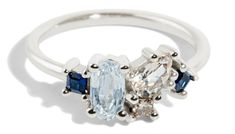 a white gold ring with two blue and white stones on the side, set in silver