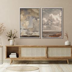 two paintings hanging on the wall above a wooden bench