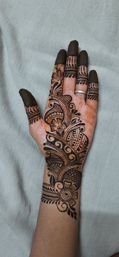 a woman's hand with henna tattoos on it