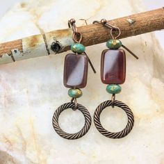 Brown Boho Dangle Earrings crafted with care, a must-have for fall.  Made with high-quality bronze finish, these earrings exude elegance and sophistication.  Adorned with captivating Czech glass beads, they add a touch of vibrancy and uniqueness to your outfit. Artisan glass beads produced in small quantities in the Czech Republic Hypoallergenic ear wires (nickel and lead free). Select ear wire style at checkout. A gift for you or someone special, earrings are carded and in an organza bag. Link Brown Brass Dangle Earrings, Brown Brass Drop Earrings, Earthy Metal Dangle Earrings, Brown Brass Jewelry With Dangling Beads, Earthy Bronze Earrings With Ear Wire, Bronze Single Earring Made Of Copper, Brown Dangle Metal Earrings, Brown Metal Dangle Earrings, Bronze Copper Earrings With Dangling Beads