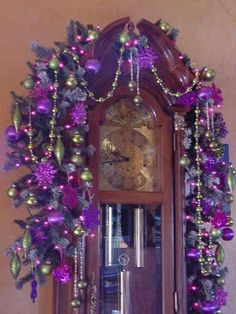 a grandfather clock decorated with purple and green ornaments