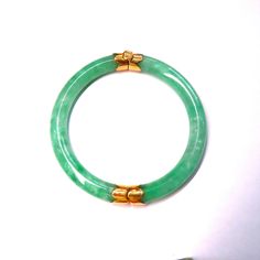 On offer is this beautiful Vintage Chinese Translucent Apple Green Jadeite Jade Sectional Bracelet Bangle with solid 14k Yellow Gold Caps and a 14k Gold Screw On Clasp.  Featuring genuine undyed and not treated Translucent Jadeite Jade that is highly polished so it gleams with a glassy luster.  The Jade is so translucent that you can see pearly whitish green veins throughout the Jadeite.  It measures 6.748 inches inner circumference x 8 mm wide.  Weight: 35 grams.  In very fine condition with no Green Classic Bangle For Formal Occasions, Classic Green Gemstone Bracelets, Classic Jade Bracelets For Formal Occasions, Elegant Oval Green Bangle, Elegant Green Oval Bangle, Classic Green Bangle Jewelry, Classic Green Round Bangle, Elegant Jade Round Bangle, Classic Green Bangle Bracelet