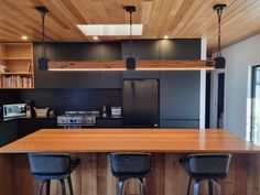 a kitchen with two bar stools next to an island