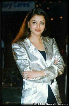 a woman in a silver blazer posing for the camera