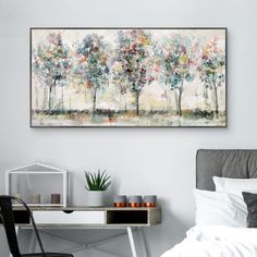 a painting hanging on the wall above a bed in a room with a desk and chair