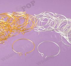 several pairs of gold and silver wire on a purple background