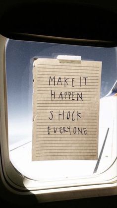 a piece of paper that says make it happen shock everyone on an airplane window sill