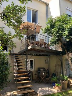 an outdoor patio with stairs leading up to the second floor