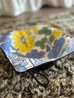 a small blue and yellow flowered bowl sitting on top of a carpet covered floor