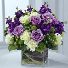 purple and white flowers in a square vase with the words sendo get well wishes