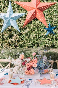 a table topped with flowers and stars hanging from the ceiling