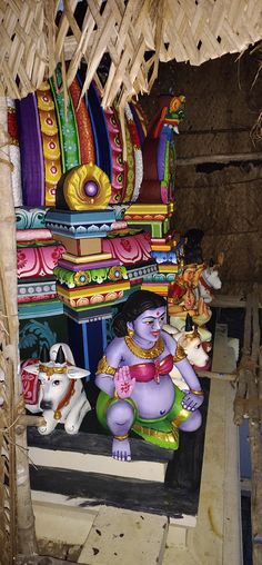 an elephant statue sitting on top of a wooden platform next to other figurines