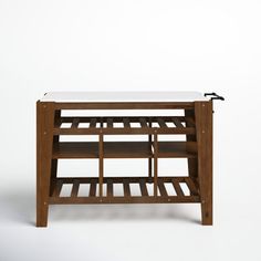 a wooden table with a white top and two shelves on each side, against a plain background