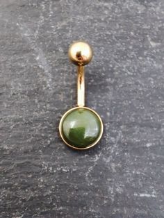 Green Natural Jade Gold Belly Bar.  *Gemstone: 8mm jade/nephrite cabochon *Design/Material: Internally threaded *Material: 316l steel, gold pvd coated *Gauge: 1.6mm (14 Gauge) *Bar Length: 6mm-12mm (1/4 inch to 1/2 inch) **The industry standard length for belly bars is 10mm. The most common size purchased from us is 8mm or 10mm. DETAILS The jade (or nephrite as it's otherwise known) cabochon is 8mm wide, setting width is about 9mm. . Each one is completely unique and they will vary from each oth Belly Bar, Belly Bars, Belly Piercing, Belly Button Piercing, Dope Jewelry, Belly Ring, Natural Jade, Belly Rings, Piercing Jewelry