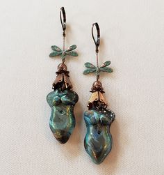 Polymer Clay Goddess Earrings. Gorgeous handmade polymer clay Goddesses made by Nevada artist Kim. These Goddesses are varied shades of rich deep greens with a metallic green and tiny sparkles finish. I accented these Goddesses with vintage copper bead caps and beautifully detailed verdigris finished brass dragonfly connectors. These earrings are 3.25 inches long including the antiqued copper finish lever back closures. Very Lightweight!! One Of A Kind I can send it gift wrapped (free of charge) Handmade Green Clay Jewelry, Green Bohemian Polymer Clay Earrings, Bohemian Green Polymer Clay Earrings, Handmade Green Clay Earrings, Green Hand Painted Copper Earrings, Hand Painted Green Copper Jewelry, Artsy Green Patina Jewelry, Modern Hand Painted Green Copper Jewelry, Modern Green Hand Painted Copper Jewelry