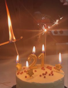 a birthday cake with lit candles in the shape of number twenty and two stars on it