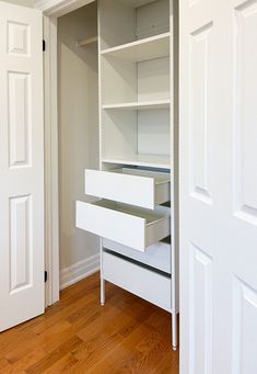 an empty closet with white shelves and drawers