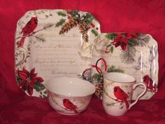 a red and white christmas themed dinnerware set on a red tablecloth with pine cones