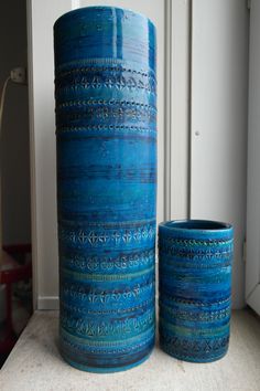 two blue vases sitting next to each other on a table