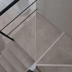 an aerial view of a stair case and handrail in a modern house with concrete flooring