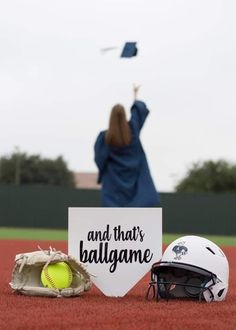 a softball mitt and helmet on the ground with a sign that says and that's ballgame