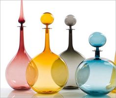 four different colored glass vases sitting next to each other