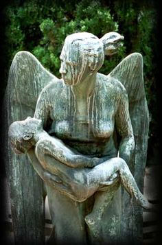 an angel statue sitting on top of a stone bench