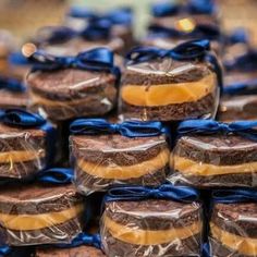 chocolate covered cookies wrapped in blue ribbon and sitting next to each other on a table