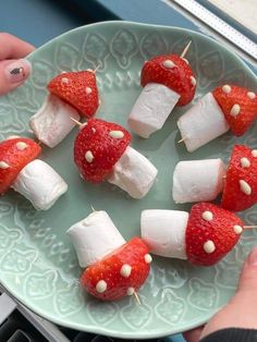 strawberries and marshmallows are arranged on skewers