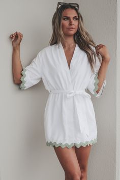 The perfect little kimono when heading anywhere sandy. White short sleeve kimono style dress, green trim detail on hems, adjustable tie belt at waist Material is Polyester Hang to dry Model is 5’9 wearing a small SHOP THE LOOK Small Medium Large Length 33” 34” 35” Bust 21” 22” 23” Spring V-neck Kimono With Belt, Summer Daywear Kimono With Tie Waist, Summer Kimono With Tie Waist For Daywear, Summer Short Sleeve Kimono For Day Out, White V-neck Kimono For Day Out, Spring Daywear Robe With Tie Waist, Chic Spring Robe With Tie Waist, Summer Lounge Robe With Tie Waist, Summer Short-sleeve Loungewear Kimono