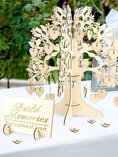 a table topped with lots of wooden cutouts next to a sign and tree on top of it