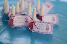 some pink and blue bottles with tags on them sitting next to each other in the middle of a table