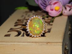 All Opals Are 100% Natural And Certified. Item details Sourced, Designed and Made BY Art Palace by MITIKA. Stone(s) : Natural Fire Opal  Total Weight : 3.92 Grams Material 925 Sterling Silver/14K Gold Silver/Gold Weight : 2.76 Grams MAIN STONE INFORMATION Stone weight : 5.40 ct. Size : 12x14 mm Shape : Oval Setting TypeProng Number Of Stones : 1 SIDE STONE INFORMATION Stone : Natural Diamond Weight : 0.38 ct. Shape : Round Number Of Stones : 24 Custom Order-------    We can craft this ring in 92 Yellow Gold Opal Ring Hallmarked As Gift, Yellow Gold Hallmarked Opal Ring For Gift, Yellow Gold Hallmarked Opal Ring As A Gift, Luxury Opal Halo Ring Gift, Luxury Opal Ring With Halo For Gift, Luxury Halo Opal Ring For Gift, Luxury Opal Ring With Halo As Gift, Oval Cluster Ring With 17 Jewels As Gift, Diamond Opal Ring Gift