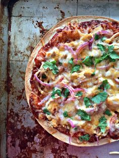 a pizza sitting on top of a pan covered in cheese and veggie toppings