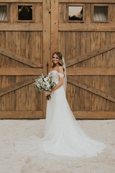 a bride standing in front of two wooden doors