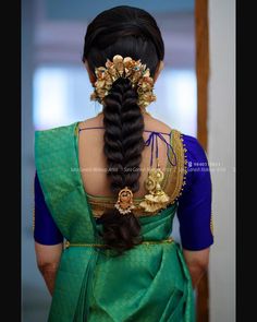 a woman with long hair wearing a green sari and gold accessories on her head