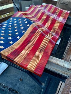 an american flag made out of wood sitting on top of a grilling pan in the back of a truck