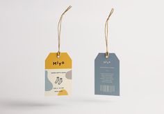 two tags hanging from strings on a white background with the words miyo printed on them