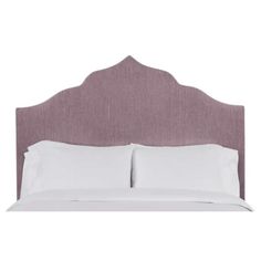 an upholstered headboard with two pillows and white sheets on the top of it