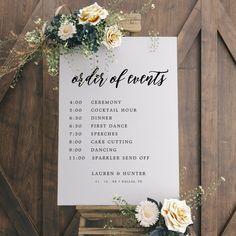 an order of events sign sitting on top of a wooden table with flowers and greenery