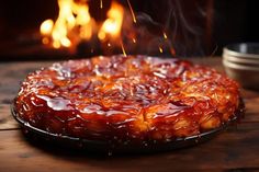 a cake sitting on top of a wooden table next to a fire