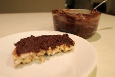 a piece of cake sitting on top of a white plate next to a bowl of food