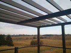 the view from an outdoor covered patio looking out on a field