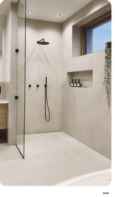 a bathroom with a walk in shower next to a sink and mirror on the wall