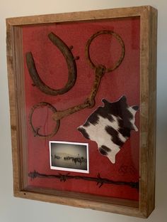 an old frame with some scissors and other things in it on the wall next to a photo