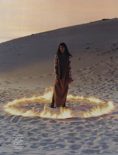 a woman standing in the middle of a circle of fire